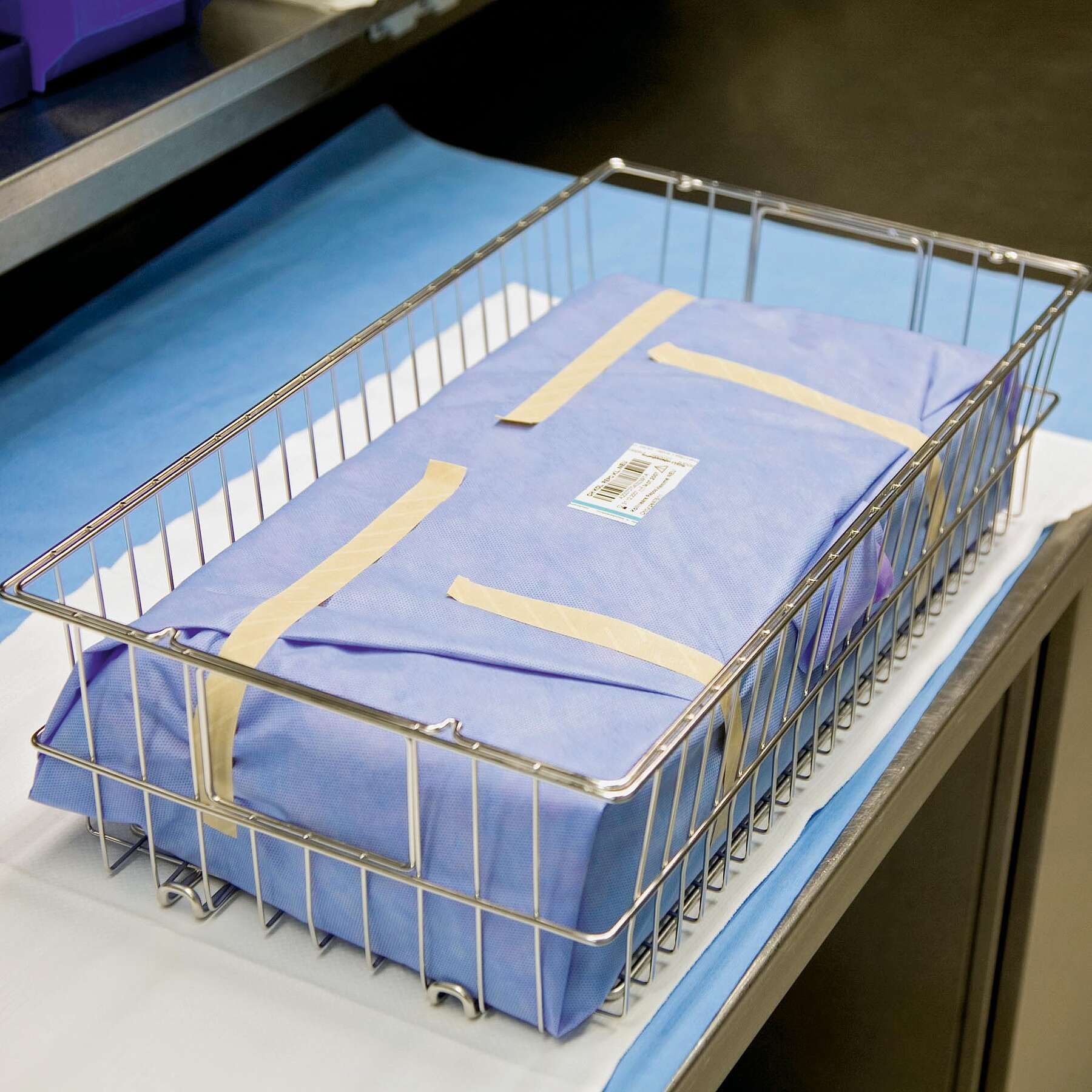 In Vlies verpacktes Verbundsieb liegt im Transportkorb, der für eine OP vorbereitet wurde. In Vlies verpacktes Verbundsieb liegt im Transportkorb, der für eine OP vorbereitet wurde.